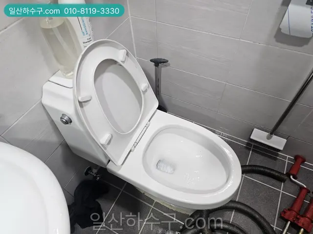 물탱크가 달린 변기 옆에 장비를 둔 화장실