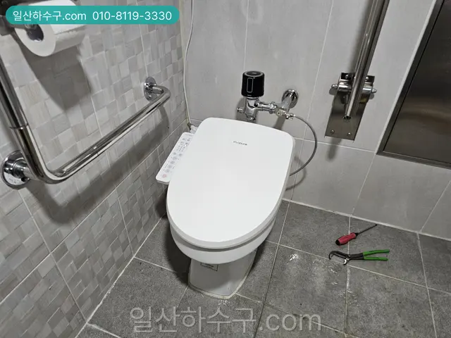 설치를 마친 비데 일체형 변기와 바닥의 공구
